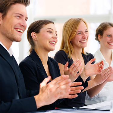 Equipo de trabajo sonriendo y aplaudiendo