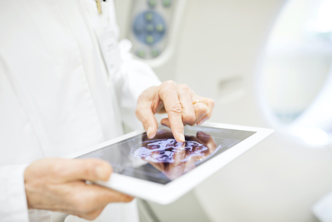 Médica revisando datos de actividad cerebral en la tablet