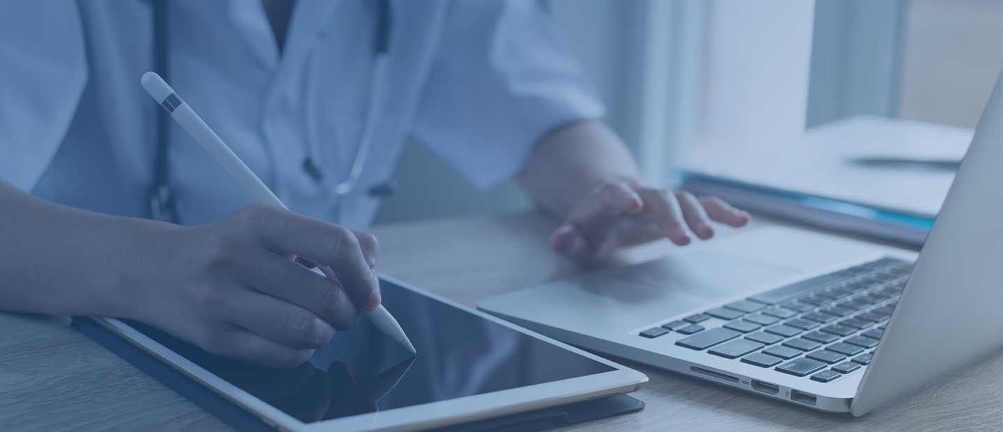 Foto de médico apuntando algo del ordenador en una tablet con velado azul