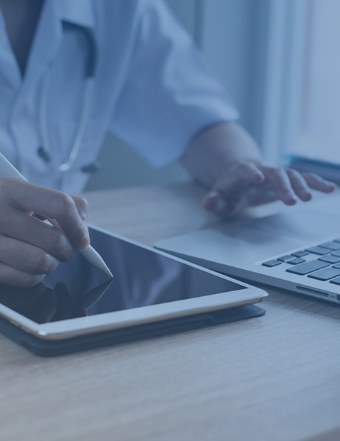 Foto de médico apuntando algo del ordenador en una tablet con velado azul