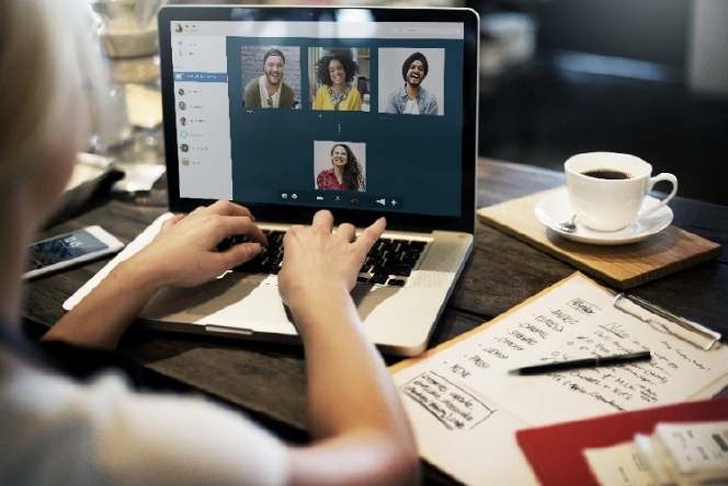 Persona trabajando y haciendo videoconferencia con sus compañeros